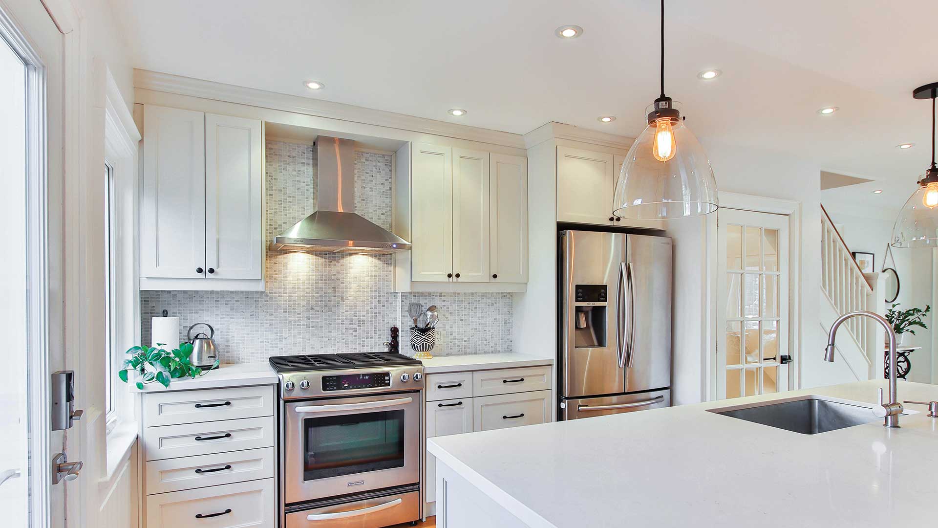 White kitchen with quartz island and pendant lighting